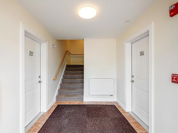 Hallway with apartment doors and staircase access at Autumn Woods Apartments, Maine