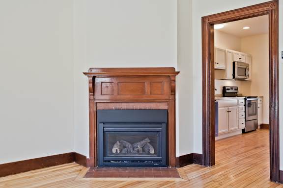 A fireplace in a room with a wooden mantle.