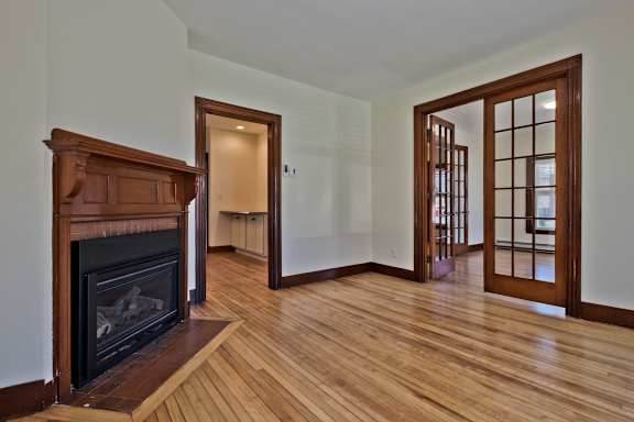 A room with a fireplace and wooden floors.