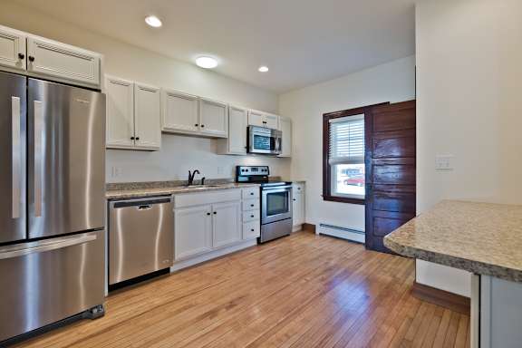 A kitchen with wooden floors and stainless steel appliances.