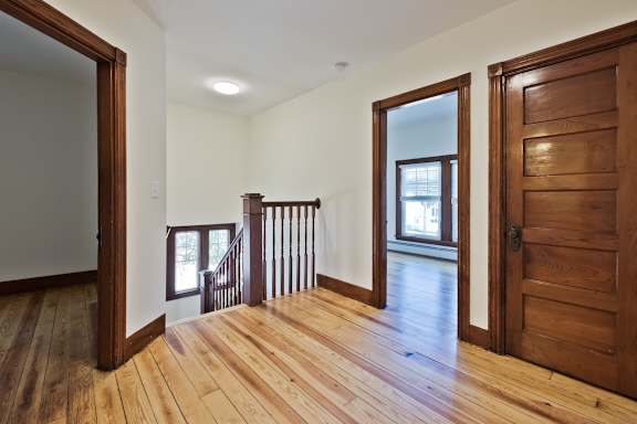 A room with wooden floors and a staircase.