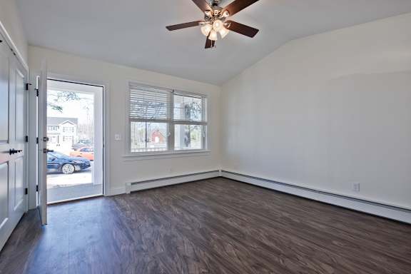 A room with a ceiling fan and a sliding glass door.