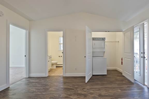 A spacious room with a toilet and sink visible through the open door.