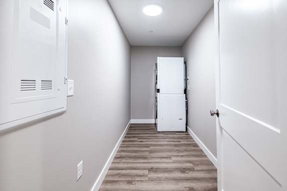 Hallway with white refrigerator and wood flooring at Windham Village Apartments, Windham, 04062