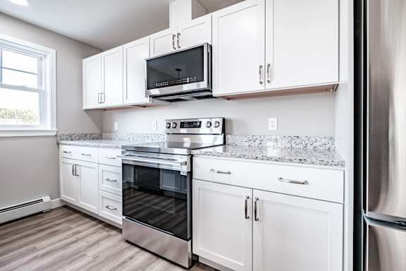 White shaker cabinets with stainless steel range at Windham Village Apartments, Maine, 04062