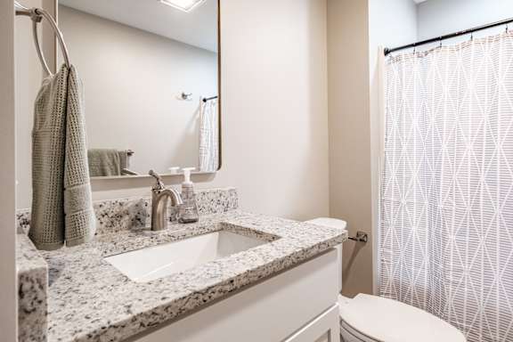 Bathroom with granite vanity and white fixtures at Windham Village Apartments, Windham, ME