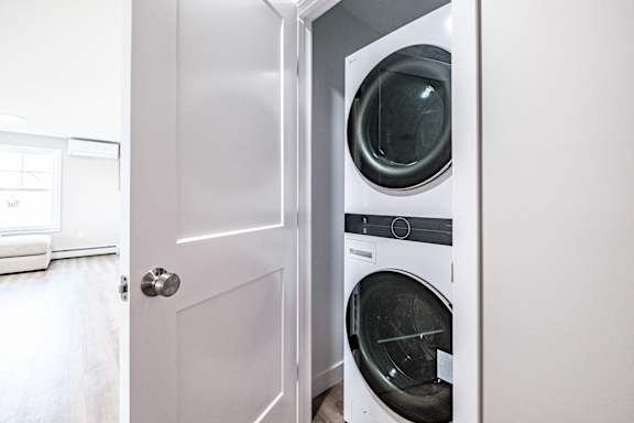 Stacked washer and dryer in closet nook at Windham Village Apartments, Windham, 04062