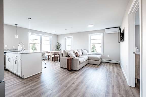 Open living space with kitchen island and seating at Windham Village Apartments, Windham