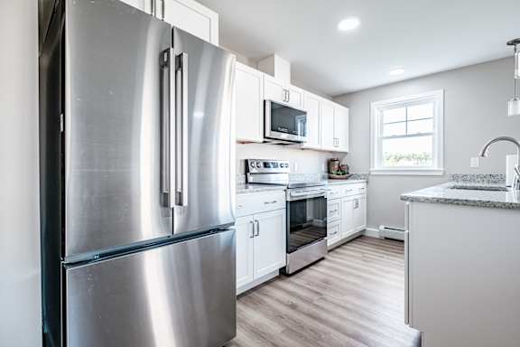 French door refrigerator in white kitchen with granite counters at Windham Village Apartments, Maine, 04062