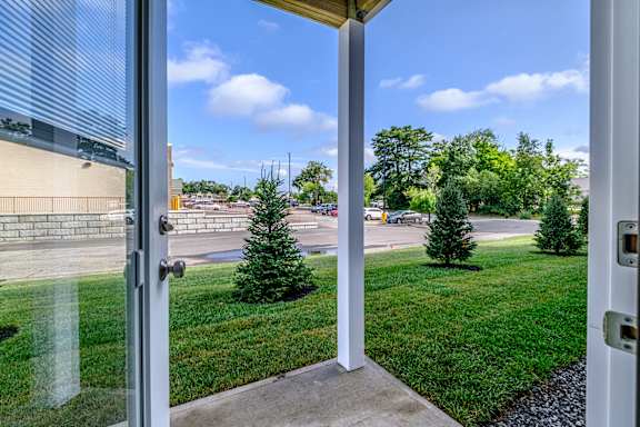 Open patio entrance with lawn and parking area at Windham Village Apartments, Windham, ME