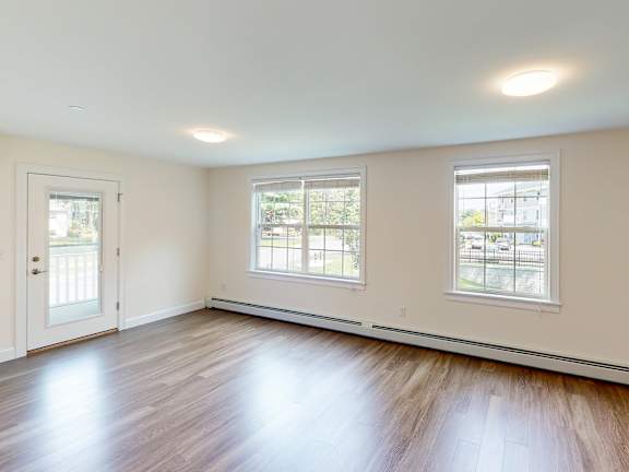 Spacious empty living room with two large windows at Autumn Woods Apartments, Westbrook, 04092