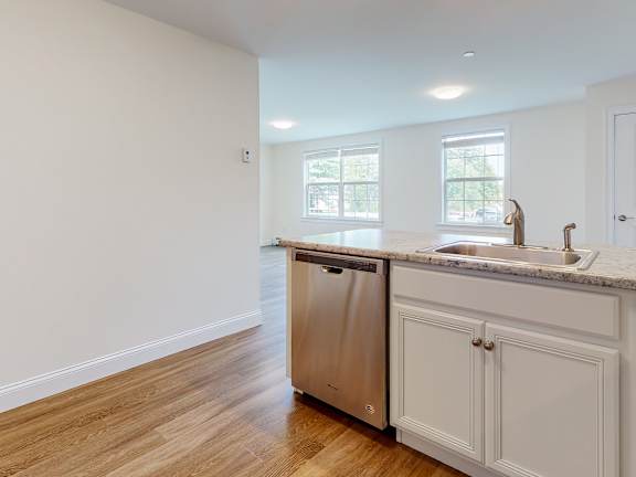 Kitchen with granite counters and stainless dishwasher at Autumn Woods Apartments, Westbrook, ME