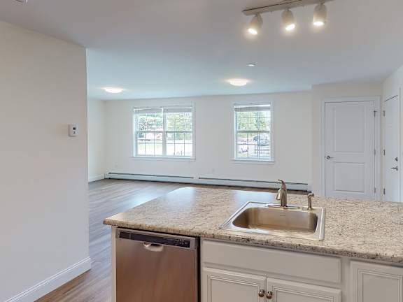 Kitchen island with granite countertop and undermount sink at Autumn Woods Apartments, Westbrook, 04092