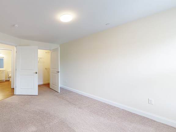 Empty carpeted room with open doors and hallway at Autumn Woods Apartments, Maine, 04092