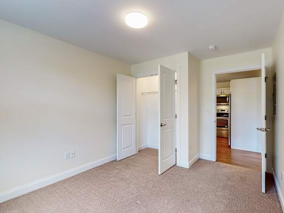 Empty carpeted room with closet and open doorway at Autumn Woods Apartments, Maine, 04092