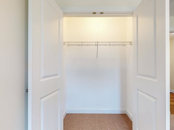 Empty walk-in closet with wire shelf and carpet at Autumn Woods Apartments, Westbrook, Maine
