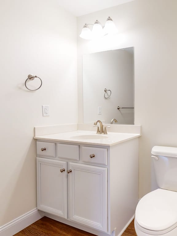 Bathroom vanity with white cabinetry and mirror at Autumn Woods Apartments, Maine, 04092