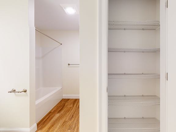 Bathroom with tub and linen closet storage at Autumn Woods Apartments, Westbrook, ME