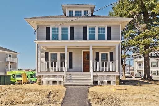 A two-story house with a front porch and a brown door.