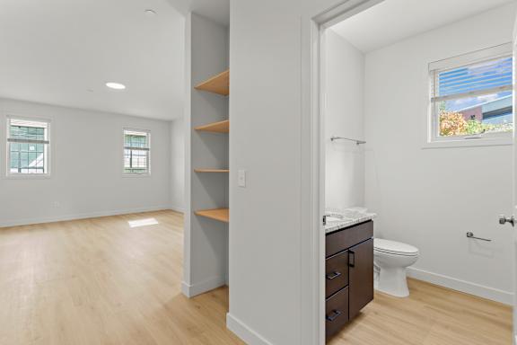a bathroom with a mirror and a toilet and a closet