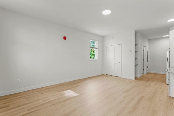 an empty living room with white walls and wood floors