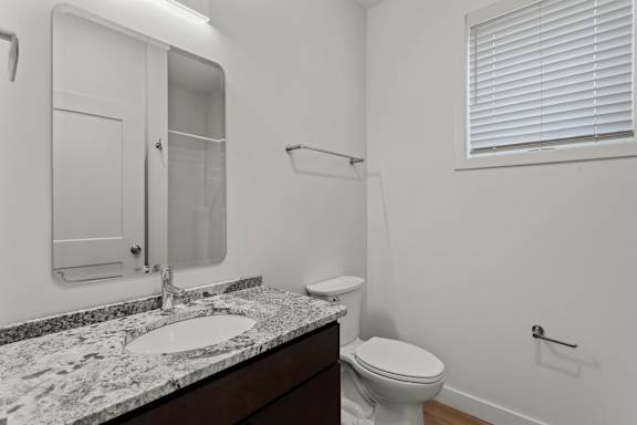 an empty bathroom with a sink and toilet and a mirror