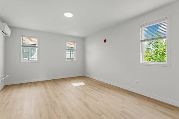 an empty living room with white walls and wood floors
