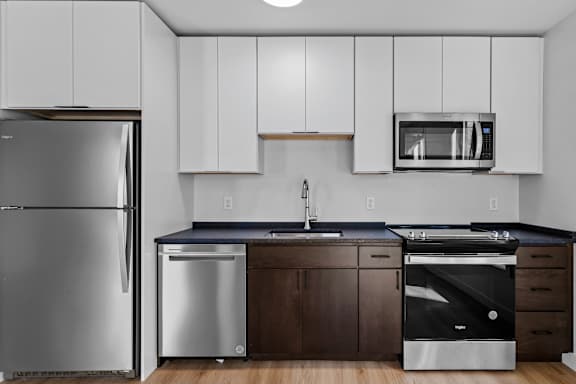 a kitchen with white cabinets and stainless steel appliances and a refrigerator