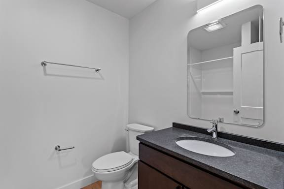 an empty bathroom with a toilet sink and mirror