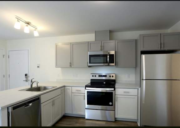 A modern kitchen with stainless steel appliances and white cabinets.