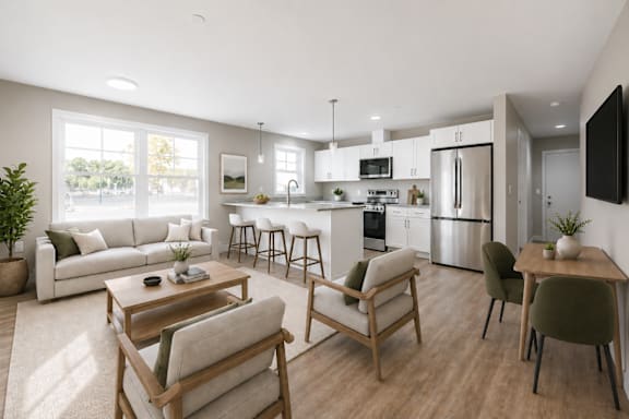 Open concept living room and kitchen with white cabinetry at Windham Village Apartments, Maine