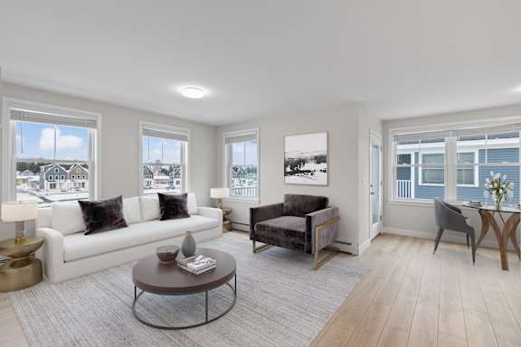 A living room with a white couch, a grey armchair, and a coffee table.
