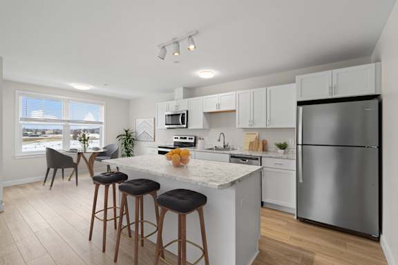 Floor Plan  A kitchen with a white countertop and stainless steel appliances.