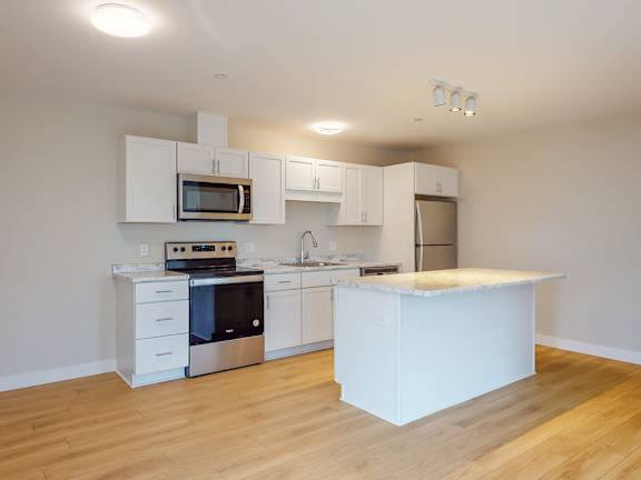 A kitchen with white cabinets and appliances.