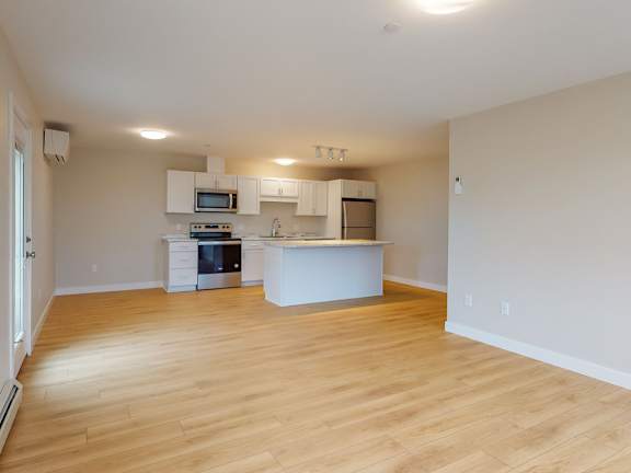 A kitchen with a white counter and wooden floors.