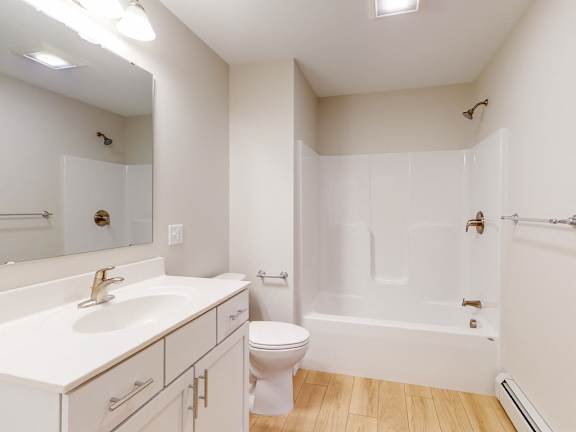 A white bathroom with a toilet, sink, and bathtub.