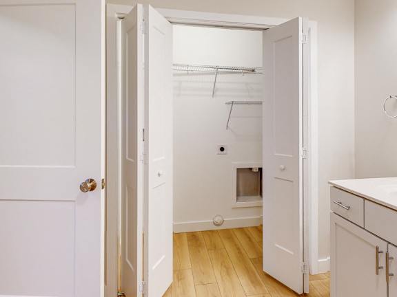 A white kitchen with a door open to a laundry room.