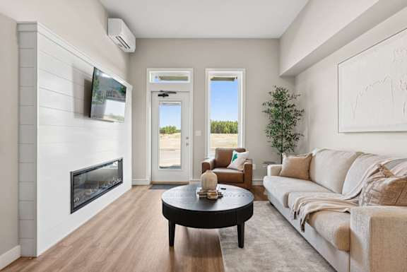A living room with a fireplace and a flat screen TV mounted above it.