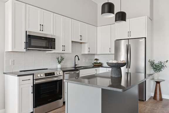 A modern kitchen with white cabinets and stainless steel appliances.