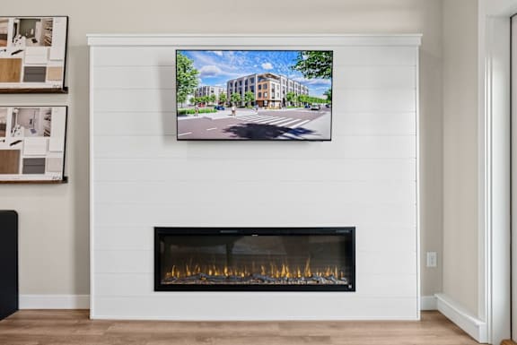 A modern living room with a fireplace and a large TV mounted above it.