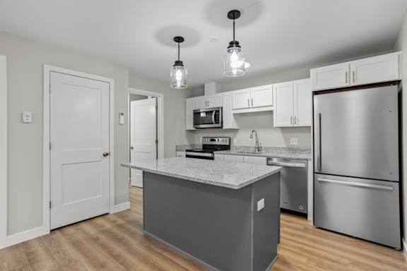 A modern kitchen with a central island and stainless steel appliances.
