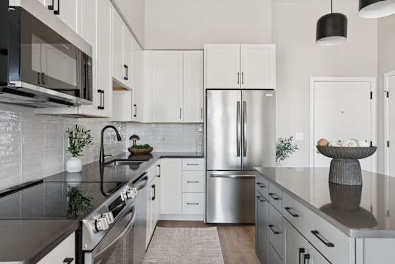 A modern kitchen with stainless steel appliances and white cabinets.