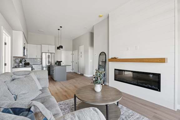 A modern living room with a grey couch and a wooden coffee table.
