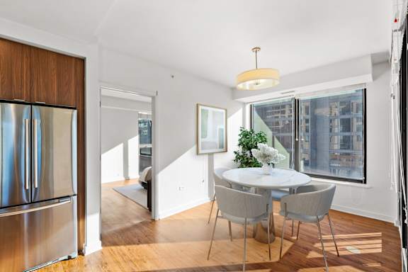 A modern dining room with a glass table and chairs at Chateau on Wells, Chicago, IL