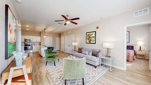 A living room with a green chair and a white couch at The Slate, Jeffersonville, 47130