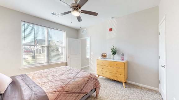 A bedroom with a bed, dresser, and window at The Slate, Jeffersonville, 47130