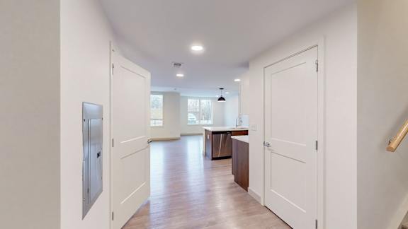 A kitchen with white cabinets and a refrigerator.
