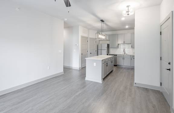 A kitchen with white cabinets and a white island.