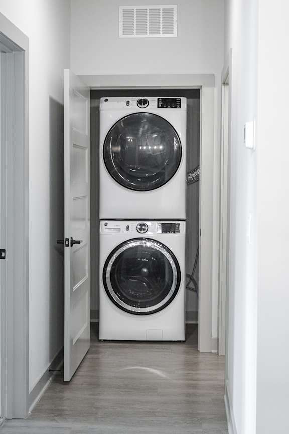A white front loading washing machine is in a doorway.