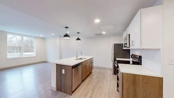 A kitchen with a refrigerator, sink, and cabinets.